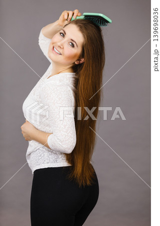 Happy woman brushing her hair Happy woman brushing her hair 139698036