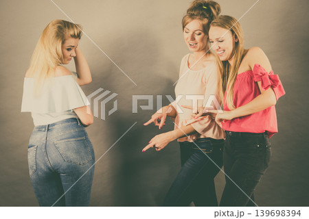 Woman being gossiped by two females Woman being gossiped by two females 139698394