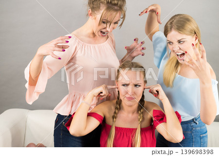 Woman being bullied by two females Woman being bullied by two females 139698398