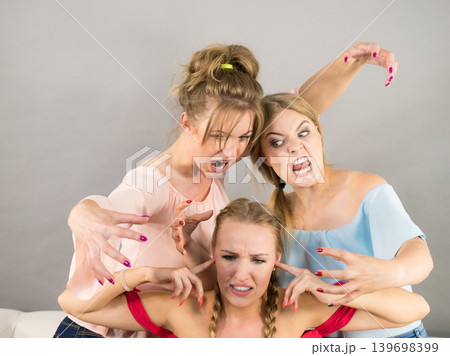Woman being bullied by two females Woman being bullied by two females 139698399