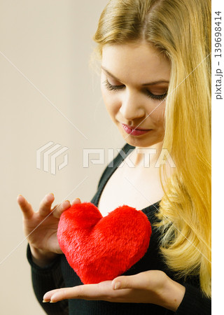 Nostalgic woman holding red heart Nostalgic woman holding red heart 139698414