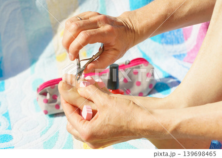 Woman trimming cuticles before pedicure Woman trimming cuticles before pedicure 139698465