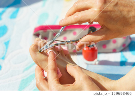 Woman trimming cuticles before pedicure Woman trimming cuticles before pedicure 139698466