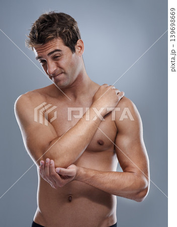 Arm, pain and man with elbow injury, medical emergency and massage tender osteoarthritis risk. Arthritis, osteoporosis and studio person with bone problem, accident or hurt anatomy on grey background 139698669
