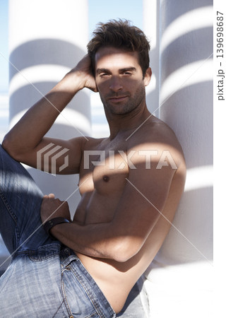 Attractive, shirtless and portrait of man outdoor by pillars in nature with confidence on vacation. Serious, model and handsome young male person by wall for holiday, adventure or weekend trip. 139698687