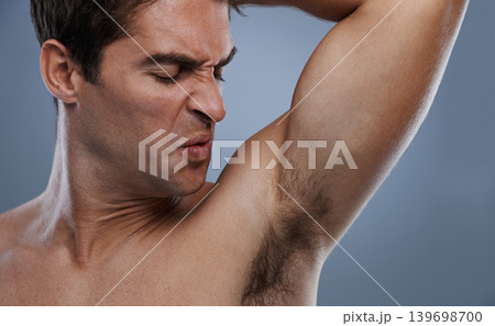 Armpit, stink and man with sweat, poor hygiene and routine on grey studio background for deodorant, cleaning and skincare. Underarm, bad smell and model with hyperhidrosis, body odor or cosmetics Armpit, stink and man with sweat, poor hygiene and routine on grey studio background for deodorant, cleaning and skincare. Underarm, bad smell and model with hyperhidrosis, body odor or cosmetics 139698700