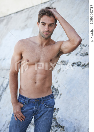Man, portrait and fitness body with confidence, stomach and wellness outdoor by a wall. Summer, workout and smile of a male model from Brazil with strong arms, torso and topless with abs and relax 139698757