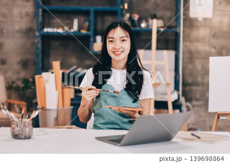 Female artist wears black hat posing near picture indoor the studio Female artist wears black hat posing near picture indoor the studio 139698864
