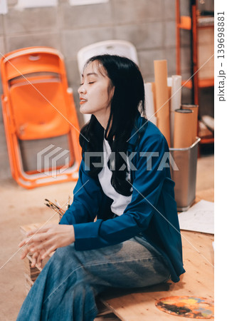 Female artist wears black hat posing near picture indoor the studio Female artist wears black hat posing near picture indoor the studio 139698881