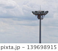 Stadium floodlight tower against cloudy sky with dramatic weather and minimal background 139698915