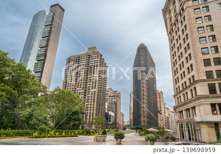 New york, usa august 18,2024. Flatiron building, featuring a classic architectural landmark, rising among modern skyscrapers in a manhattan urban park background 139698959