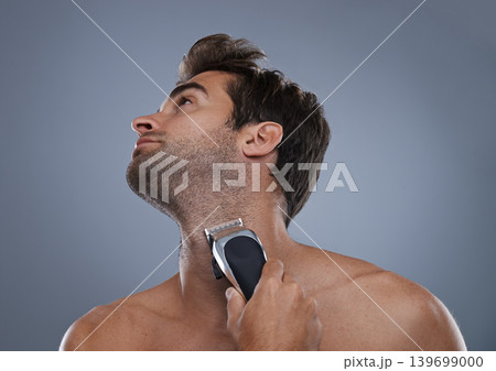 Man, electric shaver and beard in studio for grooming, skincare or wellness for neck by grey background. Person, model and self care for hygiene, facial hair removal or clippers for cosmetic change 139699000