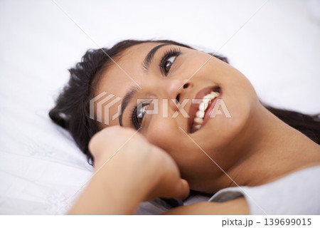 Woman, sleepy and happy relaxing in bedroom, wake up and satisfaction for wellness at home. Female person, peaceful and dreaming in apartment bed, lazy and resting or comfortable and smile in morning 139699015