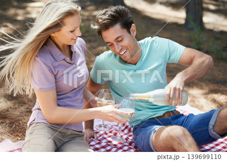 Happy couple, wine glass and picnic in nature or park for celebration of love, holiday and valentines day. Young people on a date with champagne bottle, drinks and excited for anniversary in a forest 139699110
