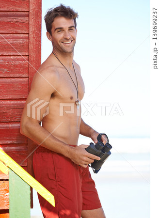 Happy man, portrait and lifeguard on beach with binoculars for scouting swimmers in health and safety. Face of male person smile in fitness for security, bay watch or patrol by the ocean coast or sea 139699237