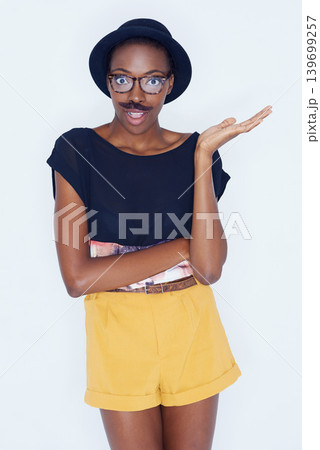 Funny, fashion and portrait of black woman with mustache in studio with hipster in white background. Silly, nerd and geek with goofy style and surprise comedy joke with trendy hat or unique outfit Funny, fashion and portrait of black woman with mustache in studio with hipster in white background. Silly, nerd and geek with goofy style and surprise comedy joke with trendy hat or unique outfit 139699257
