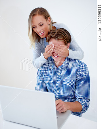 Laptop, cover eyes and couple on sofa in home for internet, online website and social networking. Happy, surprise and man and woman on computer for relaxing, streaming subscription and remote work 139699311