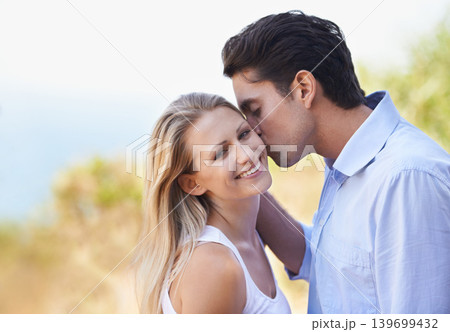 Happy couple, portrait and kiss in nature for romance, support or affection in outdoor bonding or date. Man and woman with smile on cheek for embrace, comfort or love in forest or woods together Happy couple, portrait and kiss in nature for romance, support or affection in outdoor bonding or date. Man and woman with smile on cheek for embrace, comfort or love in forest or woods together 139699432