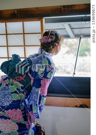 伝統的な木造建築の窓から外を眺める紫陽花柄の浴衣を着た女性の後ろ姿。愛知県、日本 伝統的な木造建築の窓から外を眺める紫陽花柄の浴衣を着た女性の後ろ姿。愛知県、日本 139699673