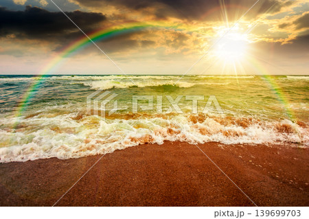 sunset over storm on the sandy beach. wonderful sea view with cloudy sky. salt water and crashing waves. view of bulgaria beach in summer. wind weather background under rainbow sunset over storm on the sandy beach. wonderful sea view with cloudy sky. salt water and crashing waves. view of bulgaria beach in summer. wind weather background under rainbow 139699703