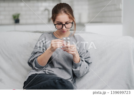 Young Girl Feels Bad At Home And Holds Pills In Hands 139699723
