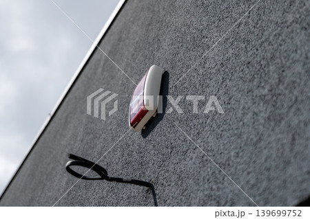A security system is mounted on the wall of a house, showing the importance of home safety and protection measures A security system is mounted on the wall of a house, showing the importance of home safety and protection measures 139699752