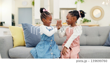 Kids, high five and couch in a home with young, smile and happy from sibling bonding together. House, lounge sofa and daughter friends with talk and girl friendship with fun and youth in living room 139699760