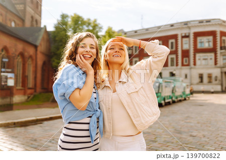 Female tourists in bright dress enjoys sights of city on sunny day. Concept of lifestyle, fashion. 139700822