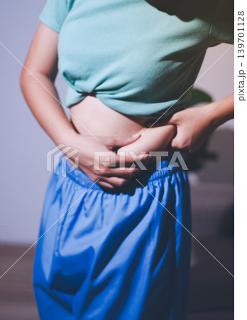 Overweight woman body with hands touching belly fat 139701128