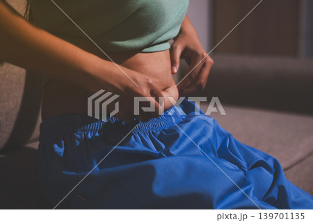 Overweight woman body with hands touching belly fat 139701135