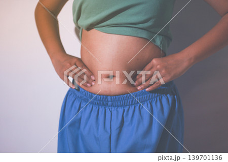 Overweight woman body with hands touching belly fat Overweight woman body with hands touching belly fat 139701136