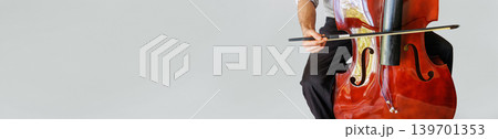 Contrabass player trying to play stringless double bass with copy space Contrabass player trying to play stringless double bass with copy space 139701353