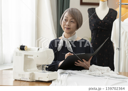 シニア女性のデザイナーがアトリエで洋服を作る 139702364