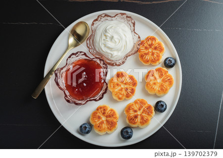 Cottage cheese pancakes, syrniki, curd fritters decorated with strawberry and raspberry served on a white plate. Homemade breakfast concept Cottage cheese pancakes, syrniki, curd fritters decorated with strawberry and raspberry served on a white plate. Homemade breakfast concept 139702379