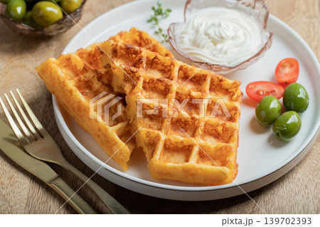 Crunchy waffle fries with sour cream dip served in a basket Crunchy waffle fries with sour cream dip served in a basket 139702393