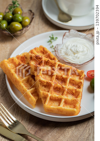 Crunchy waffle fries with sour cream dip served in a basket 139702394