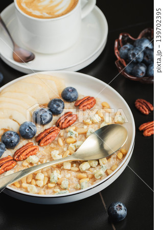 Oatmeal. Bowl of oatmeal porridge with blackberry, bananas and chia seeds on gray concrete old table background. Top view in flat lay style. Natural ingredients. Hot healthy breakfast and diet food 139702395