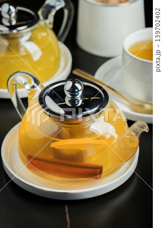 Fruit tea with mango and mint in a glass teapot on the table Fruit tea with mango and mint in a glass teapot on the table 139702402