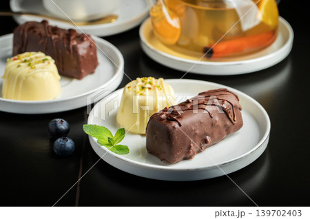 Delicious glazed curd snacks with fresh blueberries and mint on light grey table, closeup Delicious glazed curd snacks with fresh blueberries and mint on light grey table, closeup 139702403