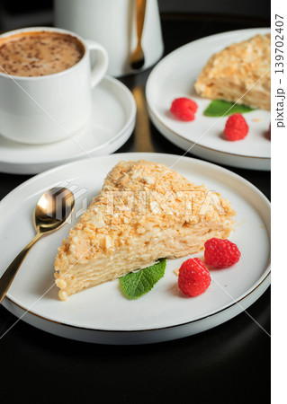 Sliced Napoleon cake on a white wooden table. Classic dessert 139702407