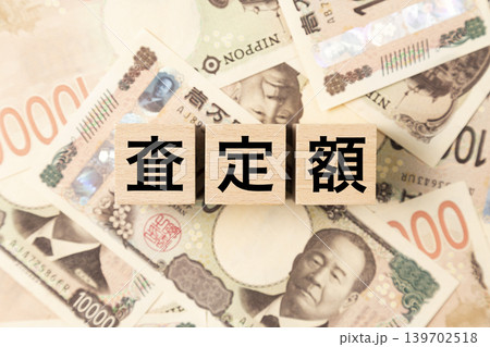 「査定額」と書かれたブロックとたくさんの一万円札 139702518