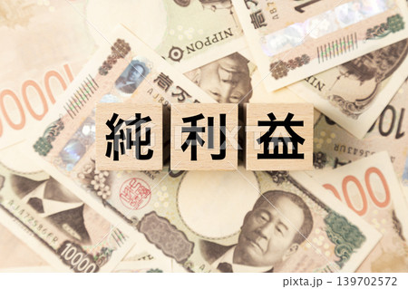 「純利益」と書かれたブロックとたくさんの一万円札 139702572
