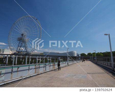 初夏の爽やかな風吹く万博公園通路。どこまでも広がる空と近代レジャー施設 初夏の爽やかな風吹く万博公園通路。どこまでも広がる空と近代レジャー施設 139702624