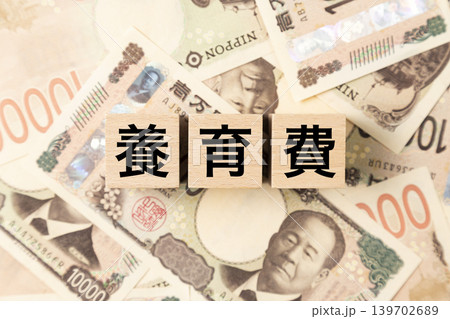 「養育費」と書かれたブロックとたくさんの一万円札 「養育費」と書かれたブロックとたくさんの一万円札 139702689