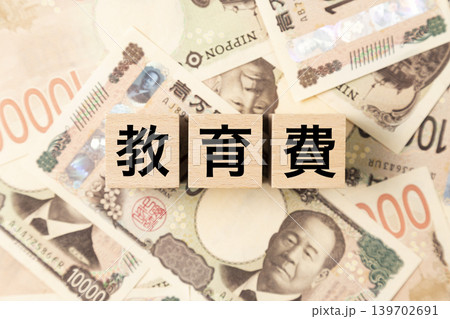 「教育費」と書かれたブロックとたくさんの一万円札 「教育費」と書かれたブロックとたくさんの一万円札 139702691