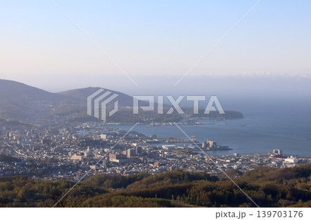 春の北海道、五月初旬、小樽市の後方、毛無山の展望所から望む北海道の小樽、港湾と石狩湾を望む、青空と夕 139703176