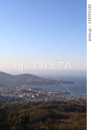 春の北海道、五月初旬、小樽市の後方、毛無山の展望所から望む北海道の小樽、港湾と石狩湾を望む、青空と夕 139703189
