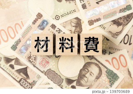 「材料費」と書かれたブロックとたくさんの一万円札 「材料費」と書かれたブロックとたくさんの一万円札 139703689