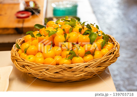 Luk Chup or Look Choop, the marzipan mung beans dessert in Thai style, molded in miniature orange fruit shape arranged in wicker basket. Luk Chup or Look Choop, the marzipan mung beans dessert in Thai style, molded in miniature orange fruit shape arranged in wicker basket. 139703718