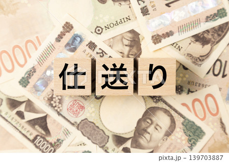 「仕送り」と書かれたブロックとたくさんの一万円札 139703887